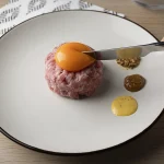plato de carne con yema de huevo